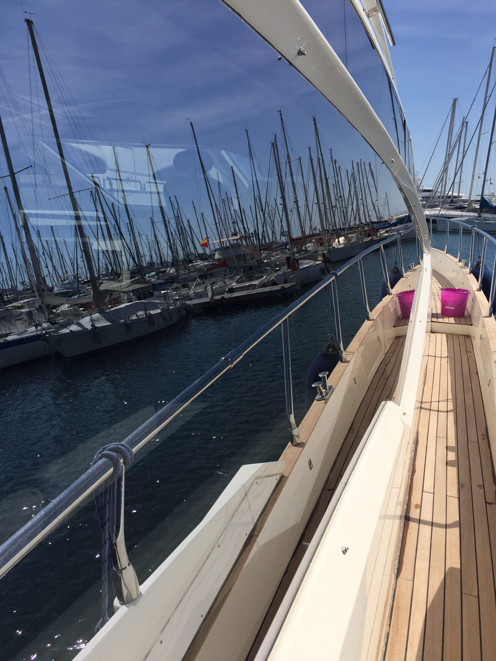 Pont en teck et coque noire vernie d'un yacht entretenu à quai